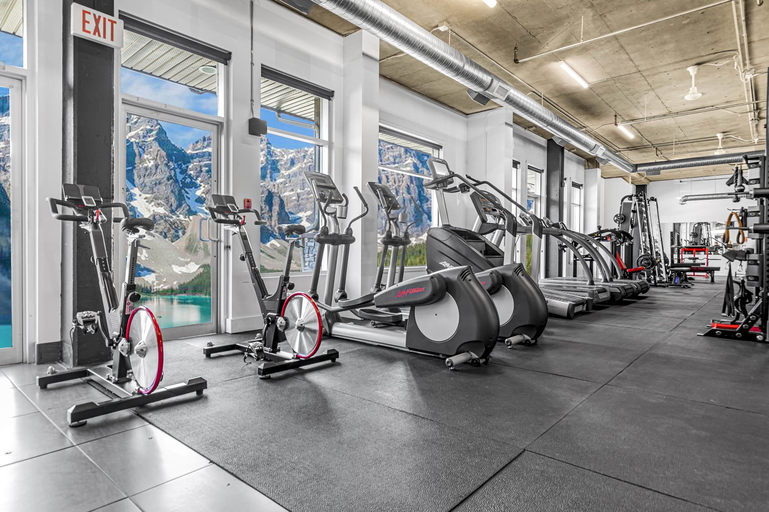 Cardio deck with treadmills and rowers facing the Canadian Rockies